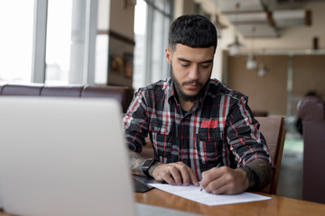 Businessman working writing documents in cafe signing contract