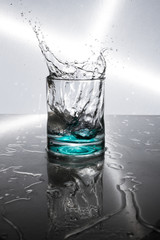 an effective splash of liquid in a glass against a dark background with spotlight