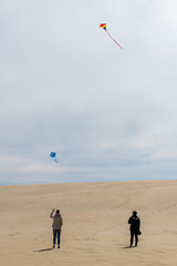 Flying a kite on the giant sand dunes of Jockey's Ridge State Park in the outer banks of North...