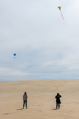 Flying a kite on the giant sand dunes of Jockey's Ridge State Park in the outer banks of North...