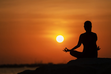 Silhouette yoga ball yong woman in the beach sunset background