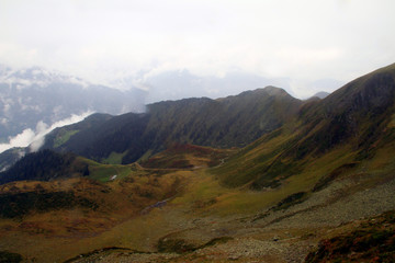 A wet day for the misty rocky mountains covered in snow and surrounded by big thick fog