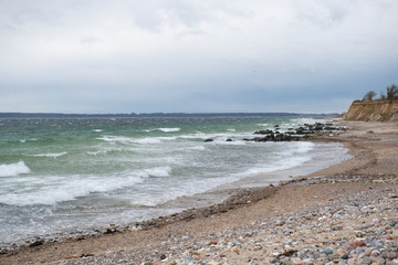 View of the baltic sea and stone beach, stormy sea waves 