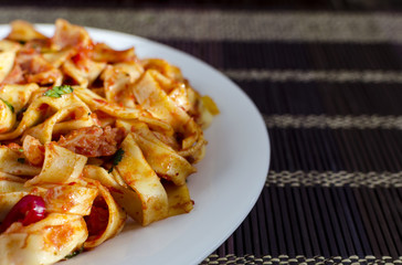 spaghetti with tomato paste on a white plate multicolor background close-up