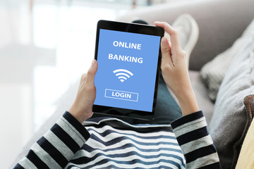 Hand using digital tablet with online bank account password login on screen over blur background,...