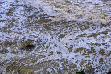Sea waves breaking on a rocks. Deep blue sea waves hit cliff, hit rocks cliff. Mighty sea waves breaking on a cliff, splashing over rocks. Strong ocean waves hitting rocks.