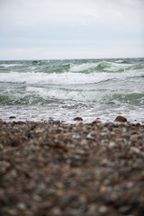 View of the baltic sea and stone beach, stormy sea waves 