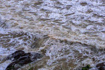 Sea waves breaking on a rocks. Deep blue sea waves hit cliff, hit rocks cliff. Mighty sea waves breaking on a cliff, splashing over rocks. Strong ocean waves hitting rocks.