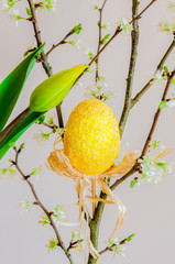 Wielkanocne jajko wiszące na gałązce  z  tulipanem - obrazy, fototapety, plakaty
