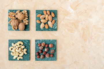 Various nuts selections . Hazelnut , almond, walnut , cashew on green marble surfaces. Top view  with space for text