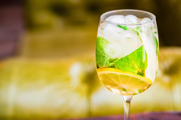 Glass with delicious fresh homemade mojito on blurred background