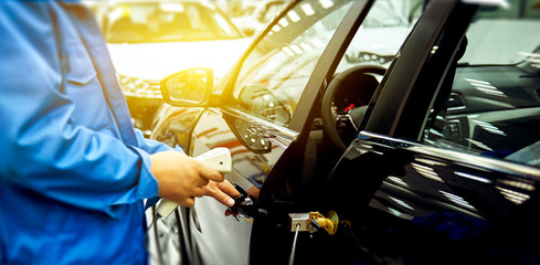 In the car production plant, engineers are using professional instruments to detect the car closing sound.