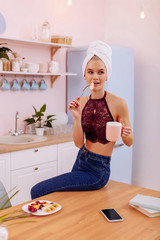 Woman with towel on her head eating pancakes in the morning