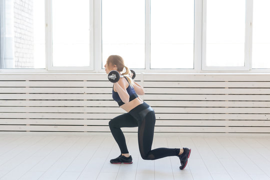 Fitness, healthy and sport concept - Woman with barbell flexing muscles and making lunge