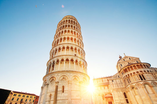 Pisa leaning tower and cathedral basilica at sunrise, Italy. Travel concept