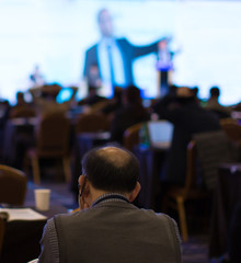 Speaker at Talk in Business Conference. Executive on Stage Photo. Senior and Elderly at Seminar. Business Presentation Presenter Speech at Tech Meeting. Corporate Forum Event for Investor Audience.