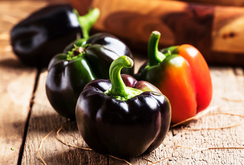 Black bell pepper, summer vegetable harvest, vintage wooden kitchen table background, selective focus