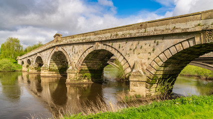 Fototapeta na wymiar Atcham Old Bridge over the River Severn in Atcham, near Shrewsbury, Shropshire, England, UK