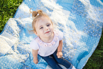 toddler girl lying on the rug on the grass