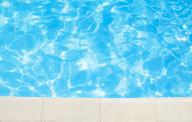 Fototapeta na wymiar Outdoor swimming pool with stone border in sunny day