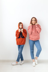 Mothers day, children and family concept - teen boy hugging his mom on white background