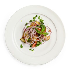 Vegetable salad on a plate, top view, on a white background