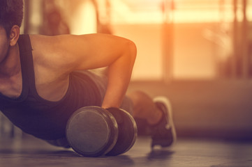 Sport. Handsome man doing push ups exercise with one hand in fitness gym.Fitness instructor at the gym - Control your mind, conquer your body.Handsome muscular man is working out with dumbbells in gym - obrazy, fototapety, plakaty