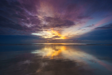 Reflection sunrise at the sea with amazing colorful sky