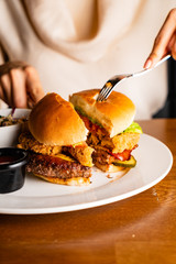 .Young woman eating burger in restaurant