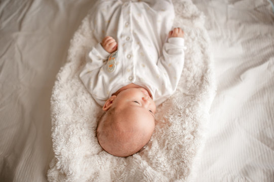 Cute baby boy in a white light bedroom Newborn baby is cute. In bedding for children born - images