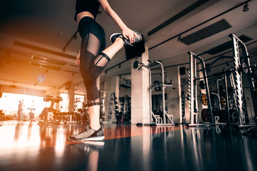 Fototapeta premium Relaxing after training.beautiful young woman looking away while sitting at gym.young female at gym taking a break from workout.