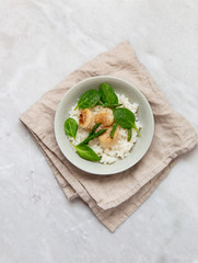 scallop risotto with asparagus, spinach in rustic plate on marble background with copy space