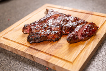 food, delicious and craft concept - cutting horse meat steak on wooden desk
