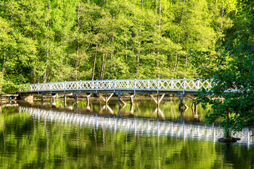Fototapeta na wymiar Wooden bridge and spring view, Mustion Linna park, Finland