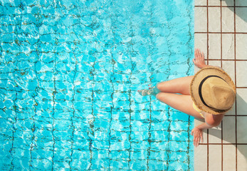Fototapeta na wymiar Young woman relaxing in swimming pool