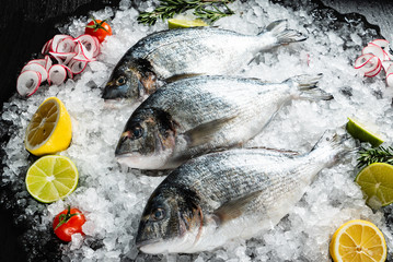 Fresh raw dorado fish and food ingredients on table