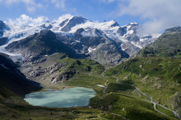 Glacier lake landscape in Switzerland with snowy mountains on background