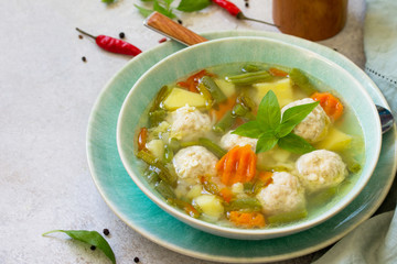 Healthy and tasty lunch. Baby food. Dietary Summer light vegetable soup with meatballs on stone table. Copy space.
