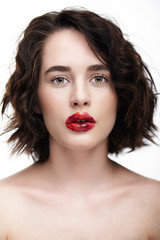 Fototapeta premium Portrait of female face. Human woman half-face with unusual beauty makeup. Girl with perfect skin, green pistachio colour eyes and scarlet red lips make-up.