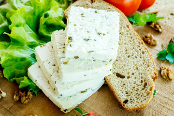 white cream cheese with herbs and spices on a wooden Board decorated with fresh dill, walnuts, green lettuce and juicy large strawberries