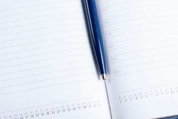 Open diary with a pen. Close-up