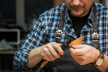 Fototapeta premium Man working with leather textile at a workshop.