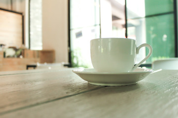 A cup of coffee at the eye view on the background of cafe interior