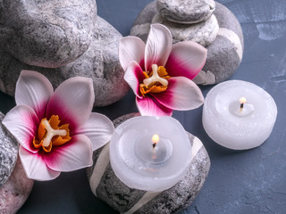 Spa composition with stones, flowers and a burning candle