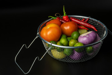 vegetables tomatoes, onions, limes, red peppers isolated on dark background