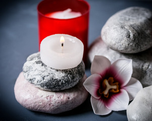 Fototapeta na wymiar Flowers, burning candle and stone for spa. Spa composition