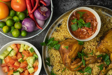 chicken mandy rice set with spicy sauce and salad on dark background