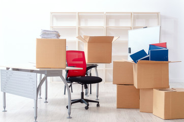 Young man employee with boxes in the office 
