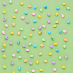 Colorful candy Easter eggs on a green background