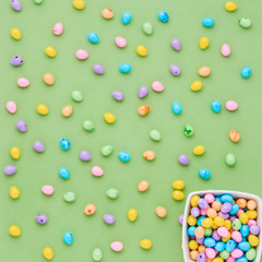 Colorful candy Easter eggs on a green background